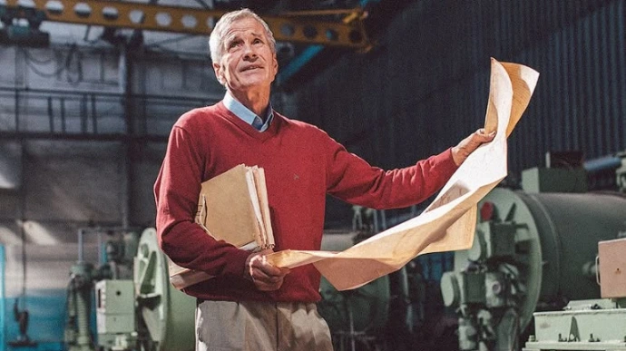 Man met tekeningen in een fabriekshal